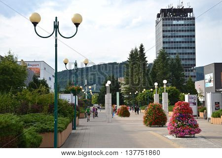 Povazska Bystrica, Slovakia - July 8, 2016: People in town centre enjoy nice day high Administrative building of state agencies in background