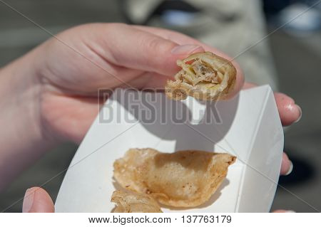 Japanese potsticker dumpling has a bite taken out.
