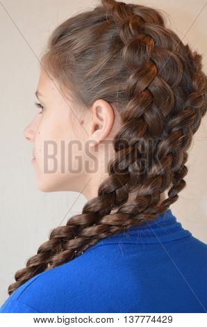 Weaving with long hair - young girl in blue on a white background