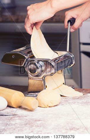 fresh pasta and pasta machine on kitchen table