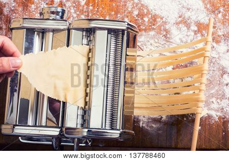 fresh pasta and pasta machine on kitchen table