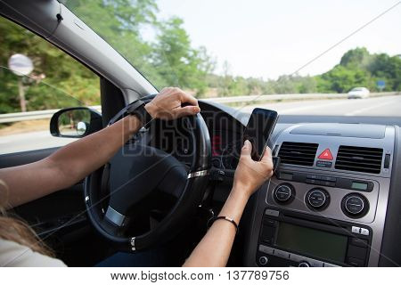 Woman driving a car and using a mobile phone