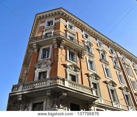 corner of a historic building with balconies on a background of clear sky
