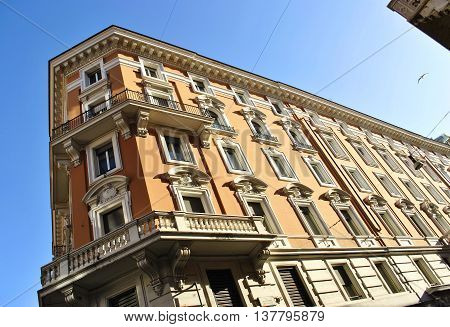 corner of a historic building with balconies on a background of clear sky