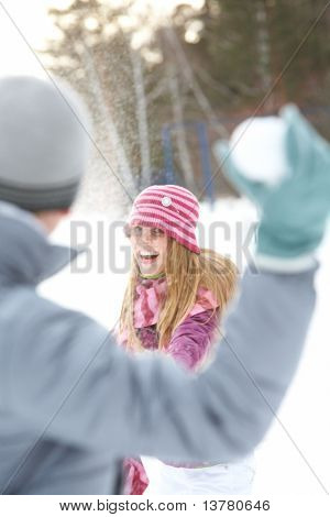 Immagini di attraente giovane donna lanciando la palla di neve e divertimento