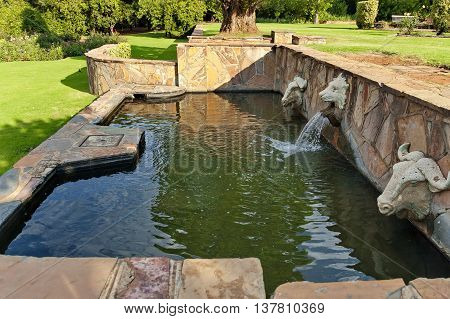 Fountain with mammal head statue in Johannesburg Botanical Garden, South Africa