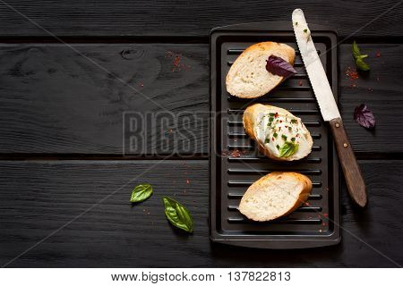 Spices cream cheese sandwiches with herbs on grill.