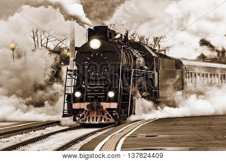 Retro steam train departs from the station.