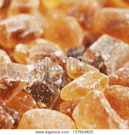 Surface coated with multiple large brown rock sugar crystals as a background composition