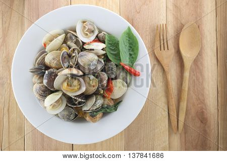 Puff meretrix or Meretrix casta is Seashell in white dish on wooden background This menu seafoods of Local Thai foods.