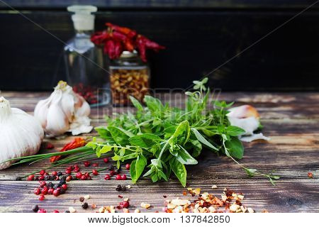 Fresh italian herbs garlic dried red hot chili peppers on old wooden background
