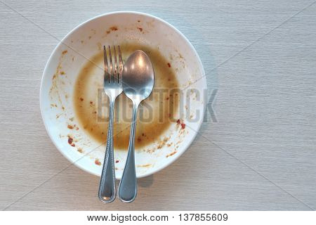 White dish have dirty after put a food and finished eating on table in the restaurant.