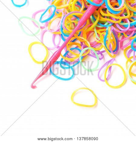 Pile of multiple colorful rubber toy loom bands isolated over the white background, close-up crop fragment foreshortening