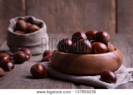 chestnuts in wooden bowl on the old wooden table
