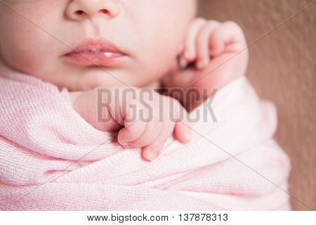 newborn baby closeup on a pink blanket