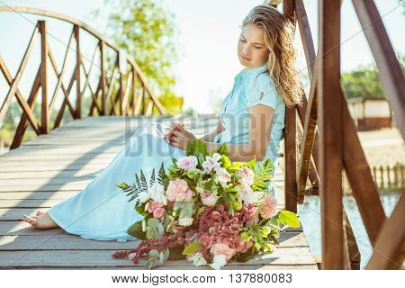 girl in a blue dress. Next to a bouquet of flowers
