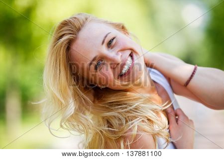 Laughing caucasian woman threw back her head and touching her neck