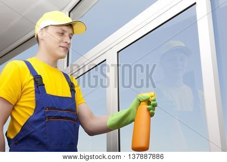 Professional cleaning. Young man washes window