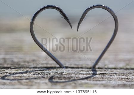 Heart Made of Two Fish Hooks on wood