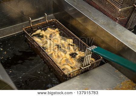 shrimpins in breadcrumbs cooking on deep fryer