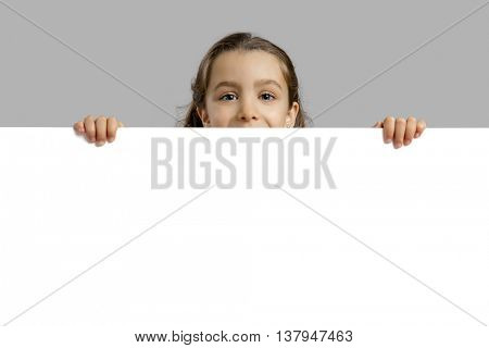 Cute little girl holding a blankboard, with copy space