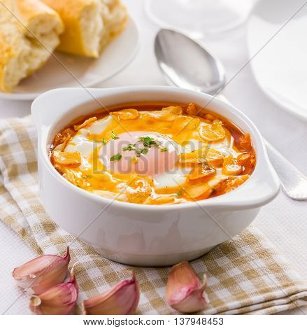 Tasty garlic soup with fried garlic clices and egg.