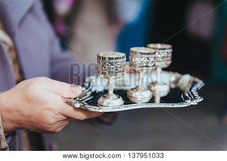 silver wine glasses on a silver plate. set of silver cups on a tray