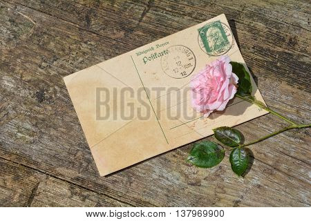old blank vintage postcard with old stamp is on old wood