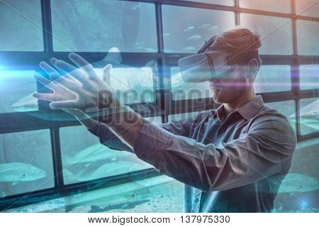 Shark swimming in fish tank against businessman using virtual reality device