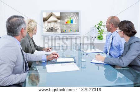 Business team looking at time clock against energy efficient house graphic against a background