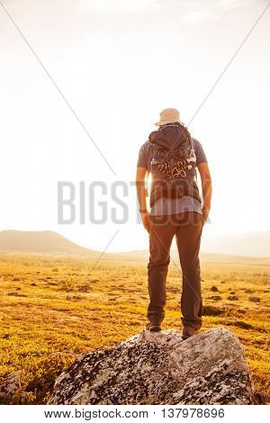 hiker with backpack traveling in Norway mountains Dovre