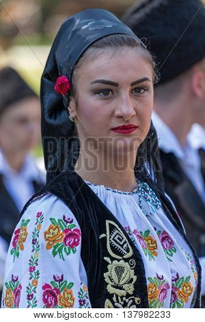 ROMANIA TIMISOARA - JULY 7 2016: Young woman from Romania in traditional costume present at the international folk festival "International Festival of hearts" organized by the City Hall Timisoara.