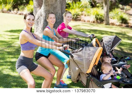 Women exercising with baby stroller in park