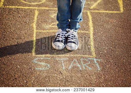 Closeup Of Boy's Legs And Playing Hopscotch On Playground Outdoors. Hopscotch Popular Street Game