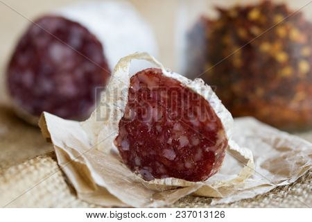 Slice Of Hot Salami With Crushed Hot Pepper On A Background