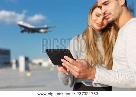 Young Couple Booing Flight On Digital Tablet Outdoor, Buying Air Ticket