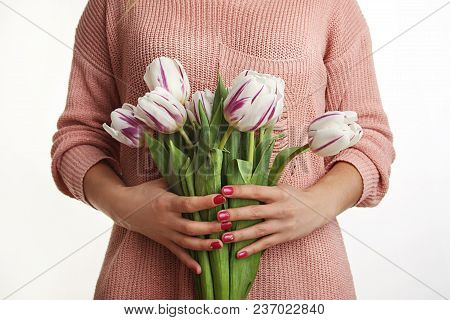 Young, Beautiful Girl Is Holding Spring Flowers In The Studio. Tulips. Portrait On White Background