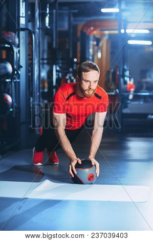 Muscular Beards Man Doing Intense Core Workout In Gym. Doing Core Exercise On Fitness Mat With Medic