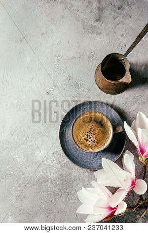 Blue Cup Of Black Espresso Coffee, Vintage Jezva And Spring Flowers Magnolia Branches Over Grey Text