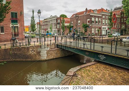 Gouda, Southern Netherlands - June 29, 2017. Walled Canal With Bascule Bridge, Trees And Brick Build