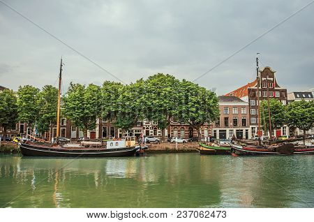 Dordrecht, Southern Netherlands - June 30, 2017. Wide Canal With Brick Building Next To It And Lots 