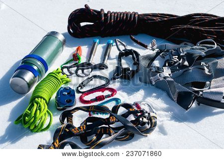 Close-up Of Winter Climbing Equipment On Fresh Snow On A Sunny Day. Carbines With A Rope Gazebo And 