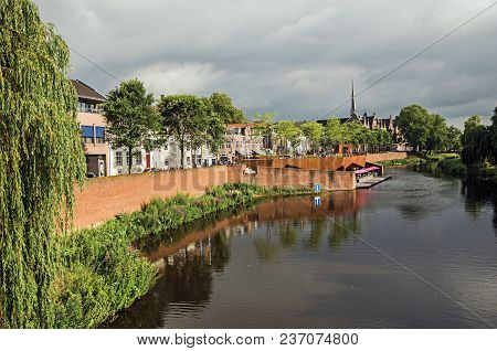 Trees, Vegetation And Houses Next To The Dommel River On Cloudy Day In The Center Of S-hertogenbosch