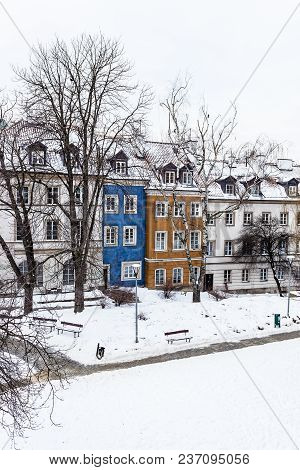 Colored Houses In Warsaw Old Town After Snow Storm In Winter, Colorful Exteriors Against The White S