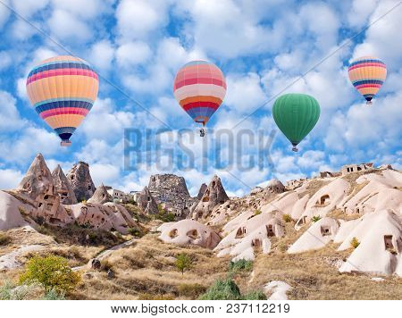 Panorama Of Uchhisar Fortress And Colorful Hot Air Balloons Flying Over Pigeon Valley In Cappadocia,