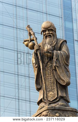 Decoration Sculpture On Daci Buddhist Temple Roof Against Modern Building In Chengdu, China