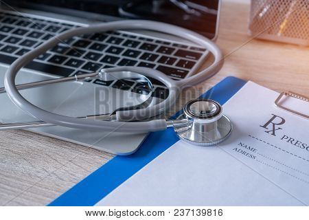 Stethoscope And Prescription Clipboard With Record Information Paper Folders On Laptop  At Medicine