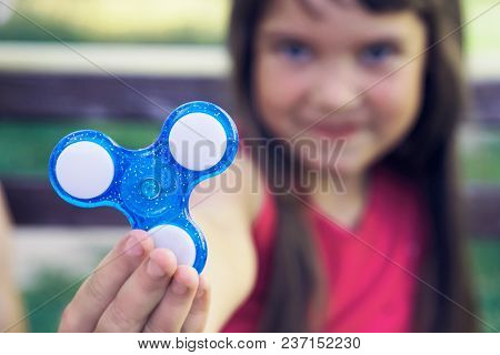 Young Girl Playy With Fidget Spinner Stress Relieving Toy. Selective Focus.