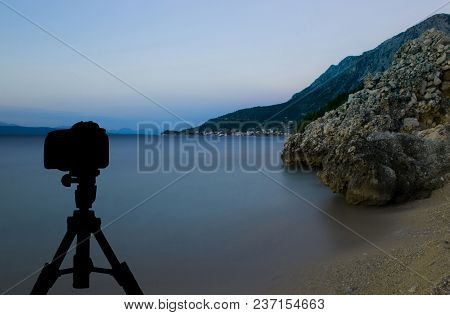 Camera On Tripod With Sunset Over The Sea In Background / Podgora, Croatia