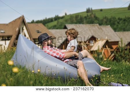 Father And Son Resting On An Air Sofa In The Mountains. Lamzac. Travel, Family Vacation In The Mount